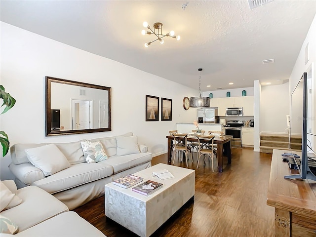 living room featuring a chandelier and dark hardwood / wood-style floors