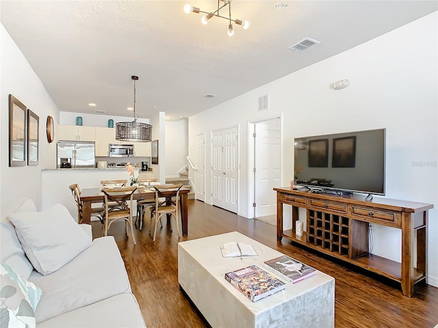 living room featuring dark hardwood / wood-style floors and an inviting chandelier