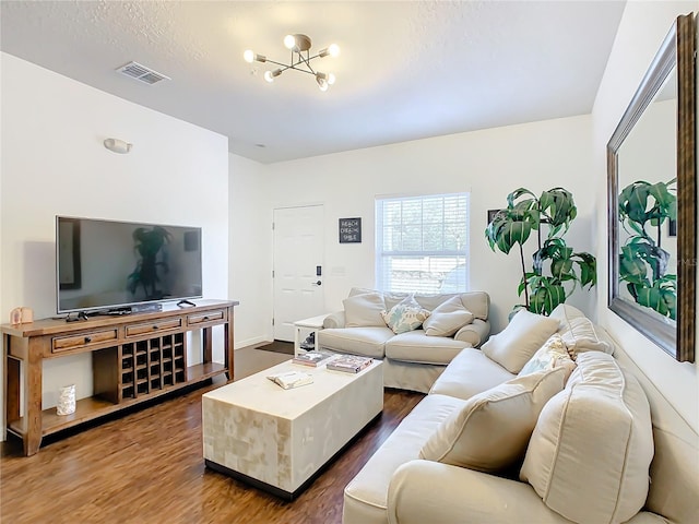 living room with a notable chandelier and dark wood-type flooring