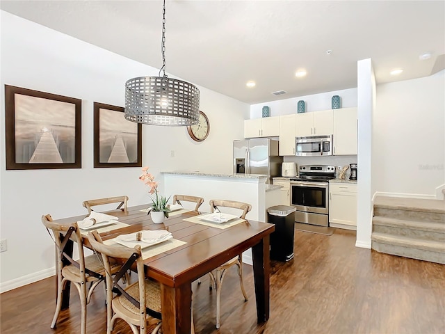 dining area featuring dark hardwood / wood-style flooring and a chandelier