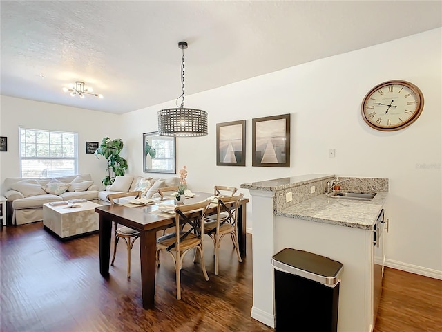 dining space featuring a notable chandelier, dark hardwood / wood-style floors, and sink