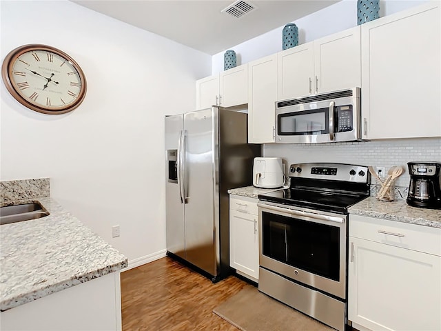 kitchen featuring white cabinetry, light hardwood / wood-style flooring, and stainless steel appliances