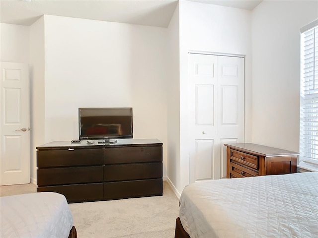 bedroom featuring a closet and light colored carpet