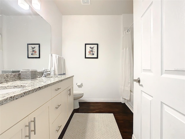 full bathroom with shower / bath combo with shower curtain, toilet, hardwood / wood-style floors, and dual vanity