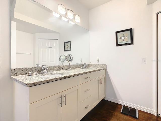 bathroom featuring oversized vanity, double sink, and hardwood / wood-style flooring