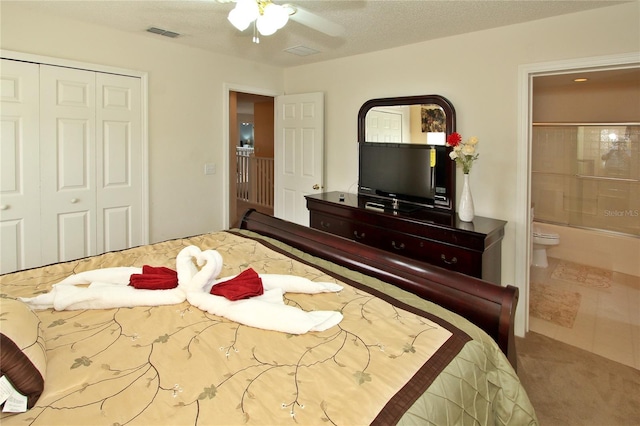 carpeted bedroom with a textured ceiling, a closet, ceiling fan, and connected bathroom