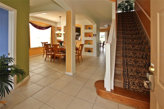 dining area featuring a chandelier, light tile patterned floors, and a textured ceiling