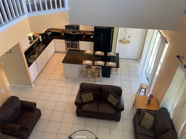 tiled living room with a towering ceiling and sink