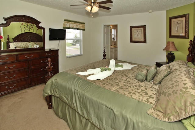 carpeted bedroom with ceiling fan, a textured ceiling, and ensuite bath