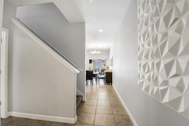 corridor with an inviting chandelier and light tile floors