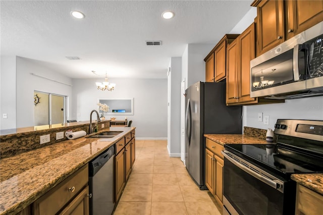 kitchen with a chandelier, light tile flooring, stainless steel appliances, stone countertops, and sink