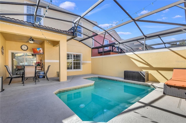 view of swimming pool with a patio, glass enclosure, ceiling fan, and central AC unit