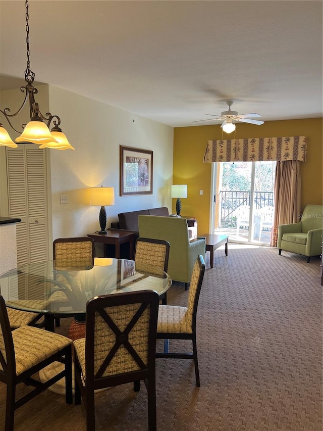 carpeted dining room featuring ceiling fan with notable chandelier