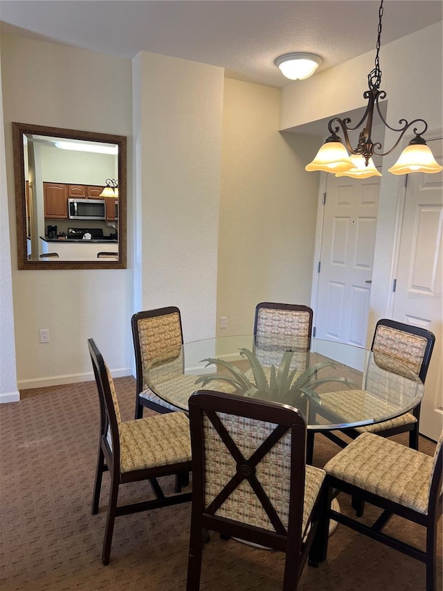 dining space with a notable chandelier and dark carpet