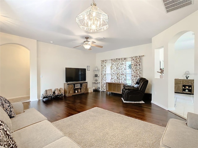 living room with dark tile flooring and ceiling fan with notable chandelier