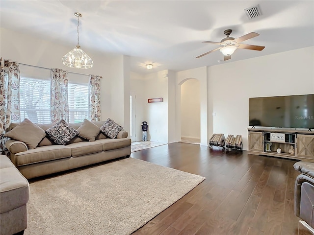 living room featuring dark hardwood / wood-style floors and ceiling fan with notable chandelier