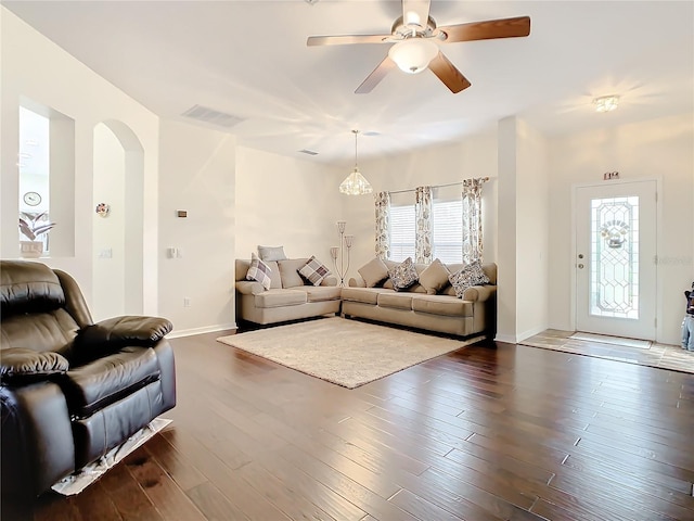 living room featuring plenty of natural light, dark hardwood / wood-style floors, and ceiling fan with notable chandelier