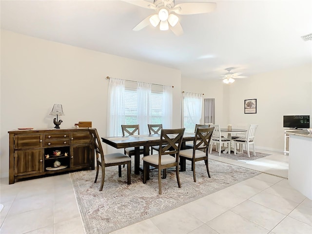 dining space featuring light tile floors and ceiling fan