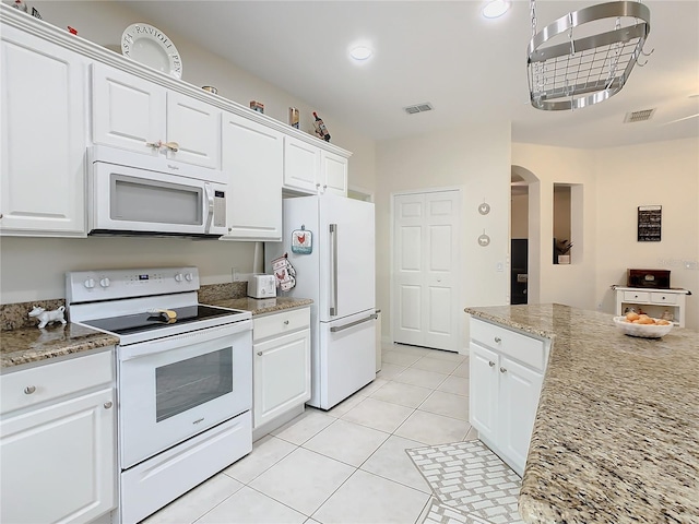 kitchen featuring white appliances, light tile flooring, white cabinets, and light stone countertops