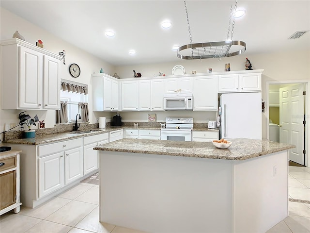 kitchen with white appliances, white cabinets, and a center island