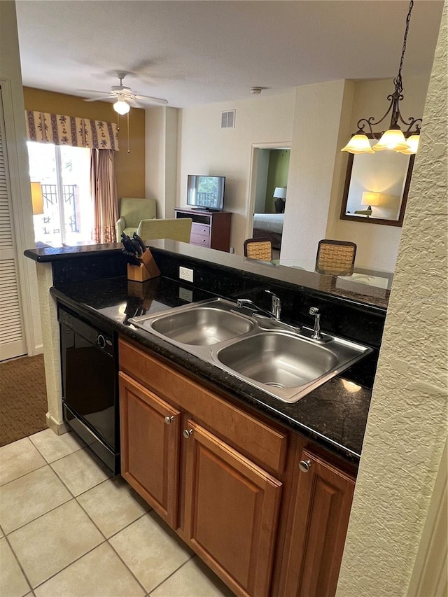 kitchen featuring hanging light fixtures, ceiling fan with notable chandelier, sink, black dishwasher, and light tile floors