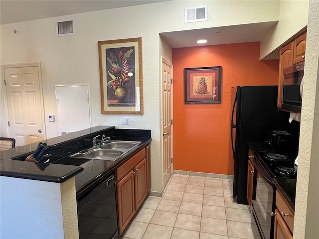 kitchen with light tile floors, kitchen peninsula, black appliances, and sink