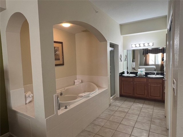 bathroom with independent shower and bath, dual vanity, and tile flooring