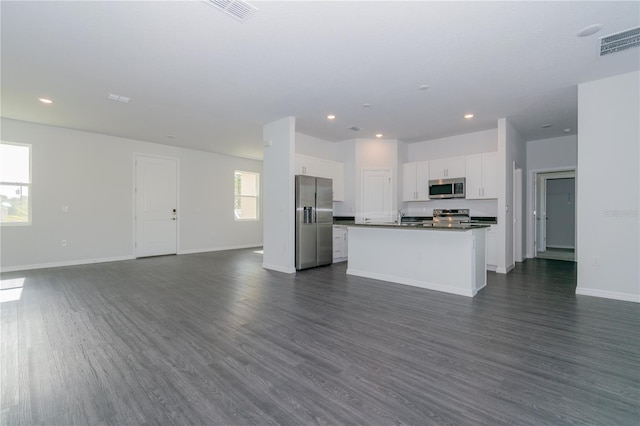 kitchen featuring white cabinets, a center island with sink, dark wood-type flooring, and appliances with stainless steel finishes