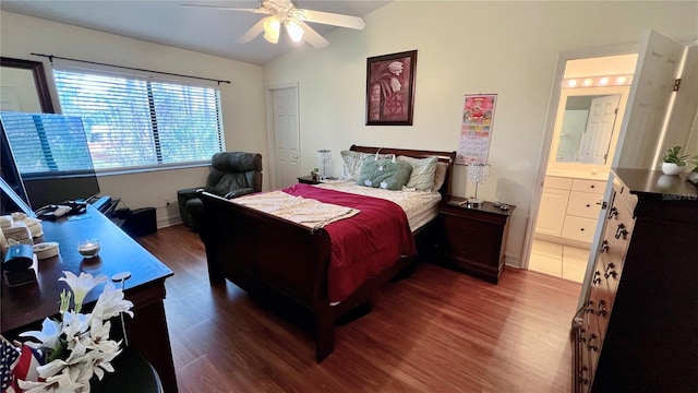 bedroom featuring ensuite bath, dark hardwood / wood-style floors, ceiling fan, and vaulted ceiling