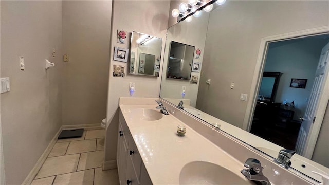 bathroom with tile flooring, large vanity, double sink, and toilet