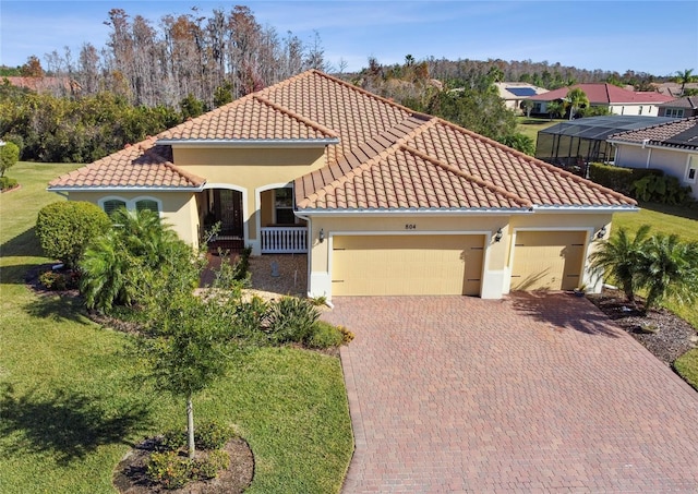 mediterranean / spanish house with a front lawn and a garage