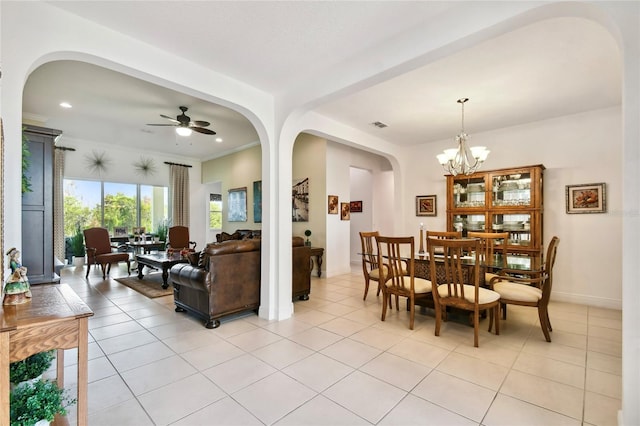 dining area featuring light tile floors and ceiling fan with notable chandelier