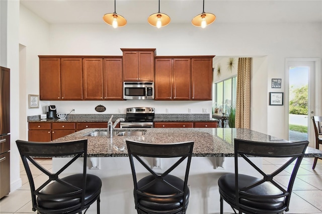 kitchen with plenty of natural light, a breakfast bar area, stainless steel appliances, and decorative light fixtures