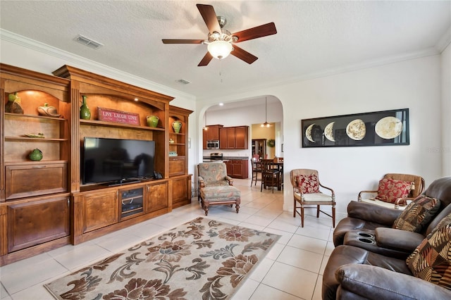 living room featuring crown molding, a textured ceiling, ceiling fan, and light tile floors