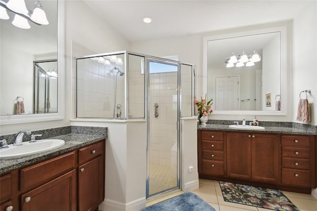 bathroom with an enclosed shower, vanity, and tile flooring