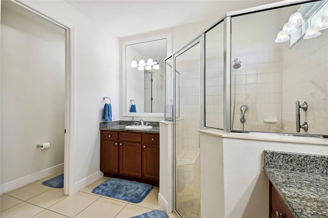 bathroom featuring tile floors, a shower with shower door, and vanity with extensive cabinet space