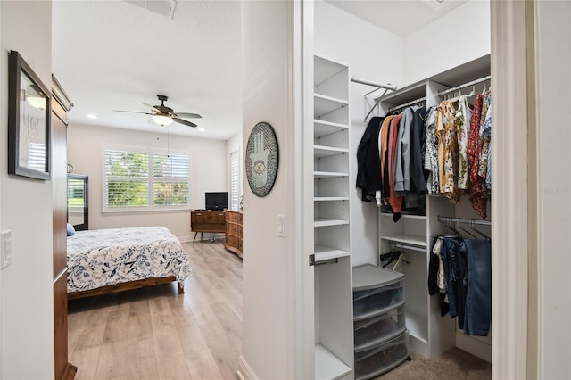 walk in closet with light hardwood / wood-style flooring and ceiling fan