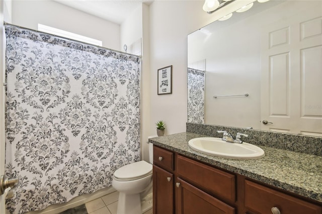 bathroom with toilet, tile floors, and vanity with extensive cabinet space