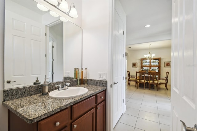 bathroom with an inviting chandelier, vanity, and tile flooring