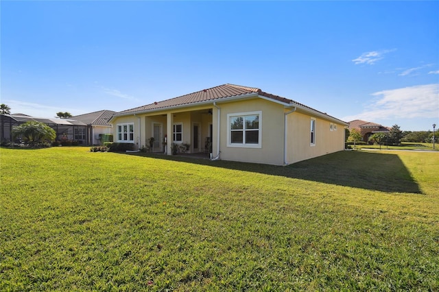 rear view of property with a yard and a lanai