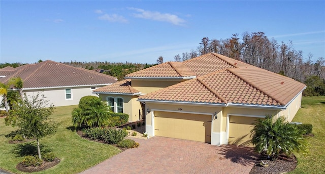 mediterranean / spanish house with a front lawn and a garage