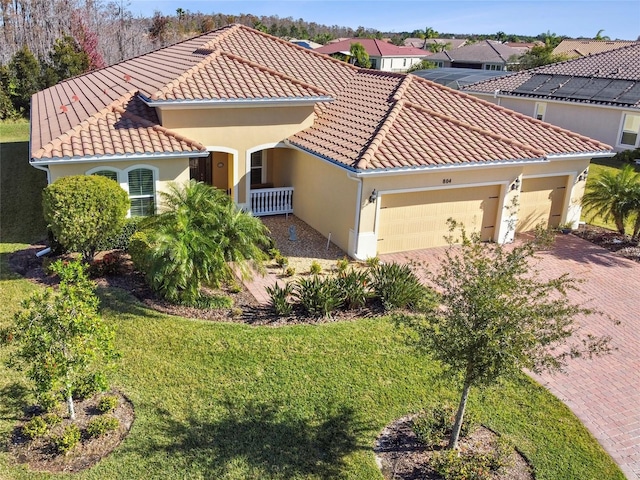 mediterranean / spanish-style home featuring a front lawn and a garage