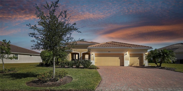 mediterranean / spanish house with a yard and a garage