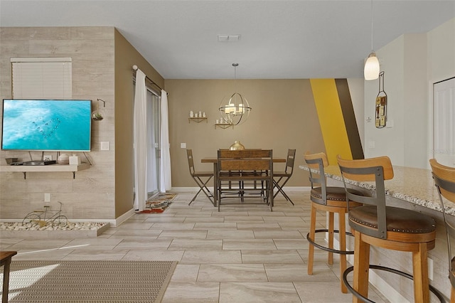 dining space featuring light tile patterned floors, a chandelier, and tile walls