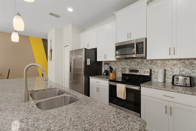 kitchen featuring appliances with stainless steel finishes, decorative backsplash, sink, light stone counters, and white cabinets