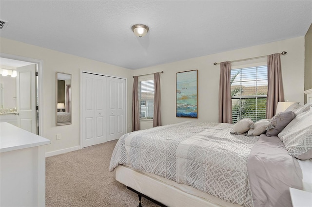 carpeted bedroom featuring a closet and ensuite bath