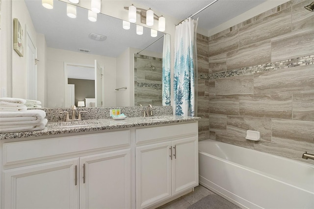 bathroom featuring double sink vanity, shower / bath combo with shower curtain, and tile patterned floors