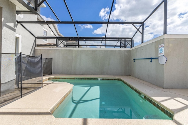 view of swimming pool featuring glass enclosure