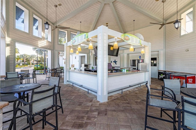 exterior space with dark tile patterned flooring, ceiling fan, and high vaulted ceiling