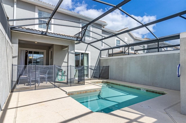 view of swimming pool with glass enclosure and a patio area